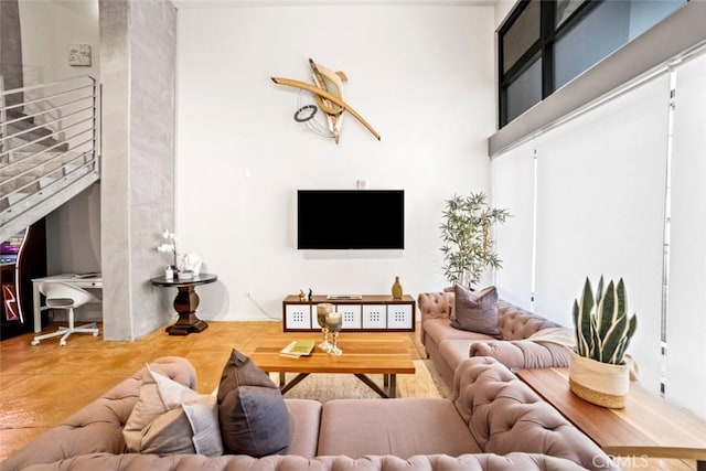 living room with concrete flooring and a high ceiling