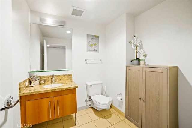 bathroom featuring vanity, tile patterned floors, and toilet