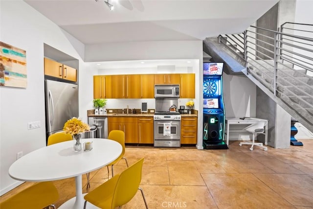 kitchen with stainless steel appliances, sink, and light tile patterned floors