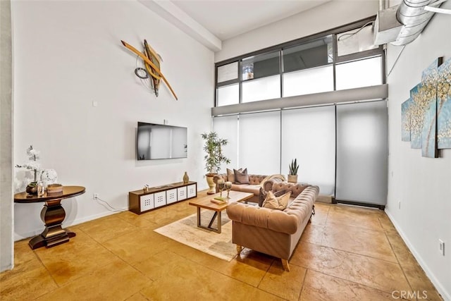 living room with a towering ceiling and a healthy amount of sunlight