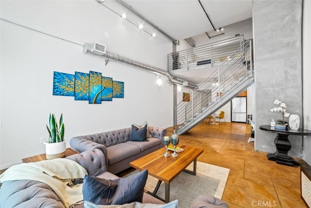 living room featuring track lighting and a high ceiling