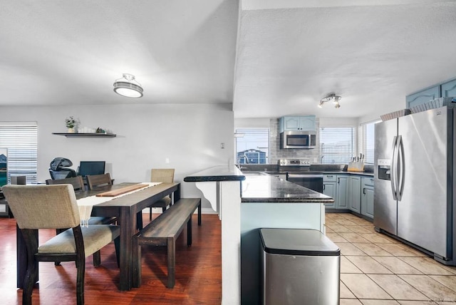 kitchen featuring tasteful backsplash, sink, light tile patterned flooring, and appliances with stainless steel finishes