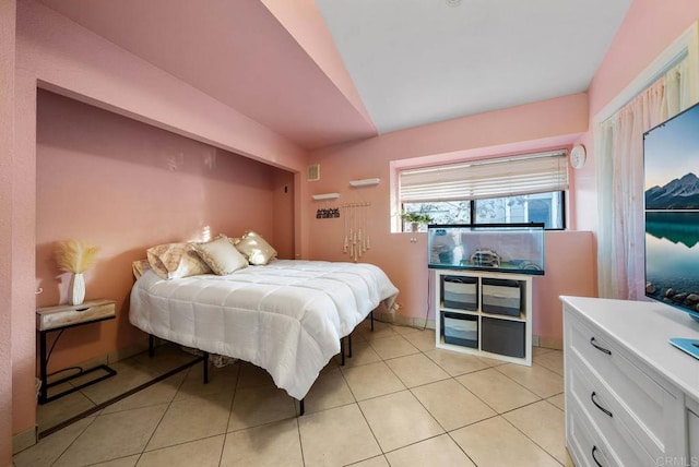 bedroom featuring vaulted ceiling and light tile patterned floors