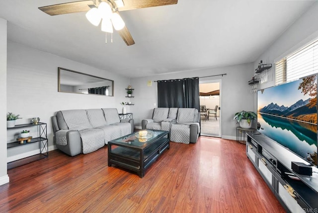 living room featuring ceiling fan and dark hardwood / wood-style flooring