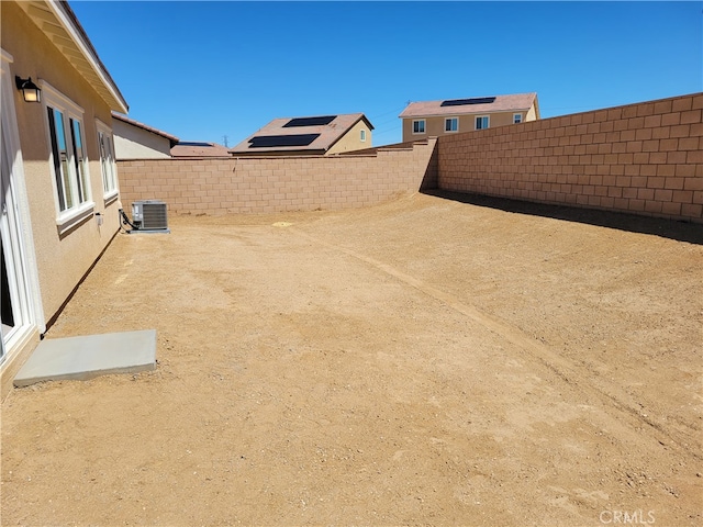 view of yard with central AC unit and a fenced backyard