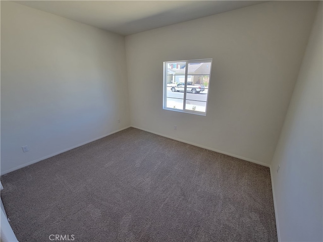 empty room featuring baseboards and carpet flooring