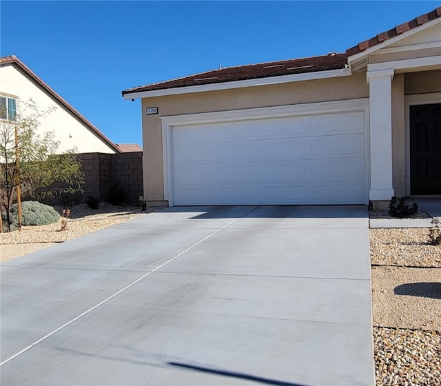 garage with driveway and fence