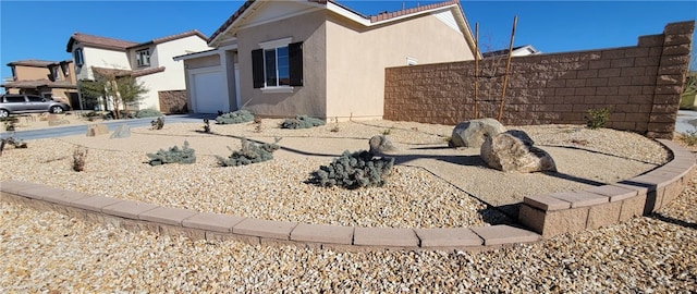 view of home's exterior featuring concrete driveway, an attached garage, fence, and stucco siding