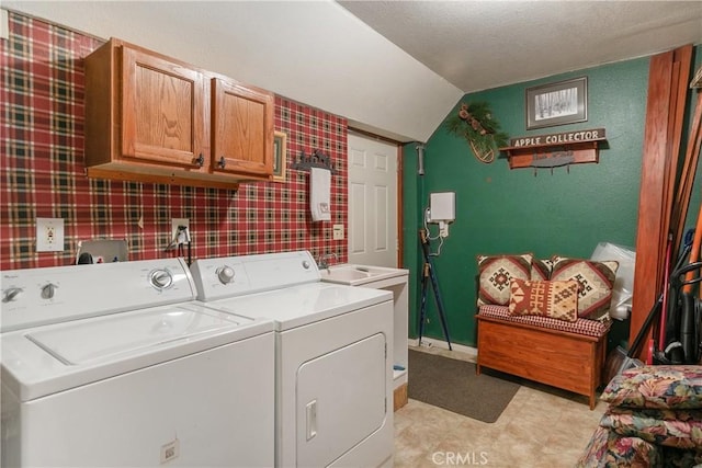 clothes washing area featuring cabinets and washer and clothes dryer