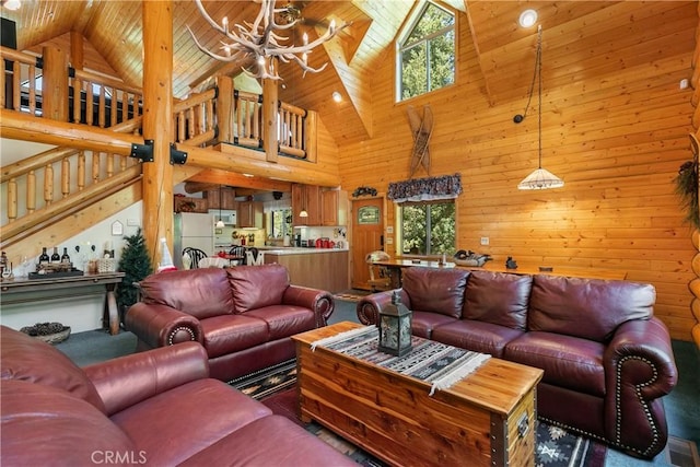 living room with high vaulted ceiling, wood walls, a notable chandelier, a healthy amount of sunlight, and wooden ceiling