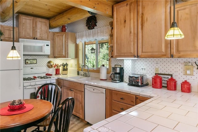 kitchen with beam ceiling, sink, tile countertops, and white appliances