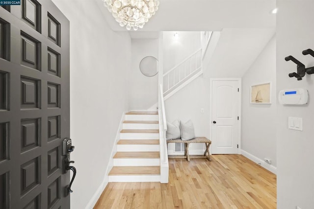 foyer with an inviting chandelier and light hardwood / wood-style flooring