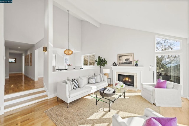 living room with beamed ceiling, high vaulted ceiling, a fireplace, and hardwood / wood-style floors