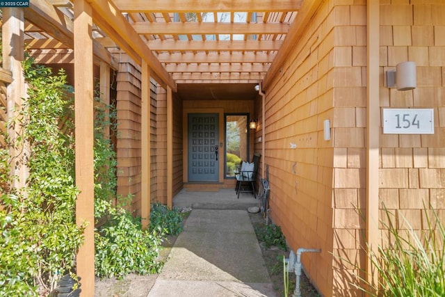 property entrance with a pergola