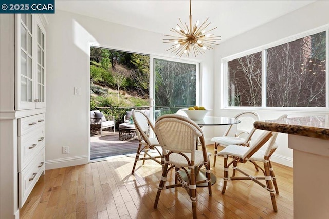 sunroom / solarium featuring breakfast area and a notable chandelier