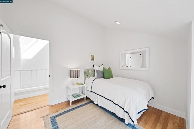 bedroom featuring hardwood / wood-style flooring and vaulted ceiling