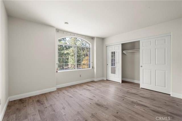 unfurnished bedroom with hardwood / wood-style flooring and a closet