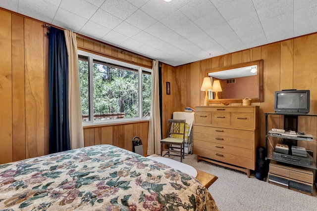 bedroom with wooden walls and carpet