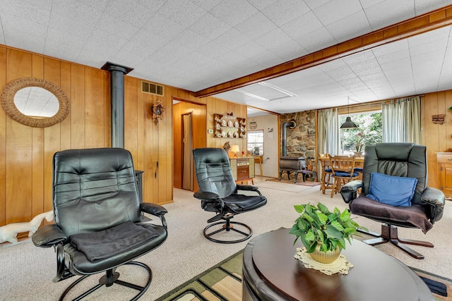 carpeted living room featuring plenty of natural light and a wood stove