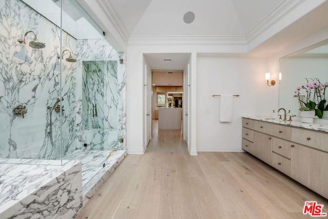 bathroom with hardwood / wood-style flooring, ornamental molding, a tile shower, and vanity