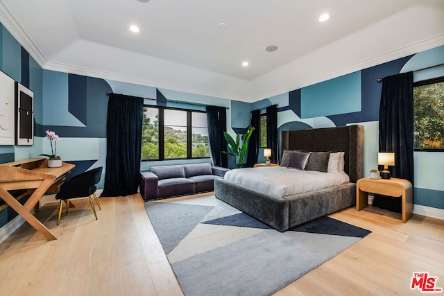 bedroom featuring a raised ceiling, crown molding, and light hardwood / wood-style floors