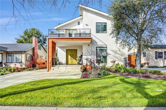 back of property with a balcony and a yard