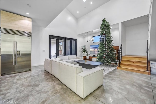 living room with a towering ceiling and plenty of natural light