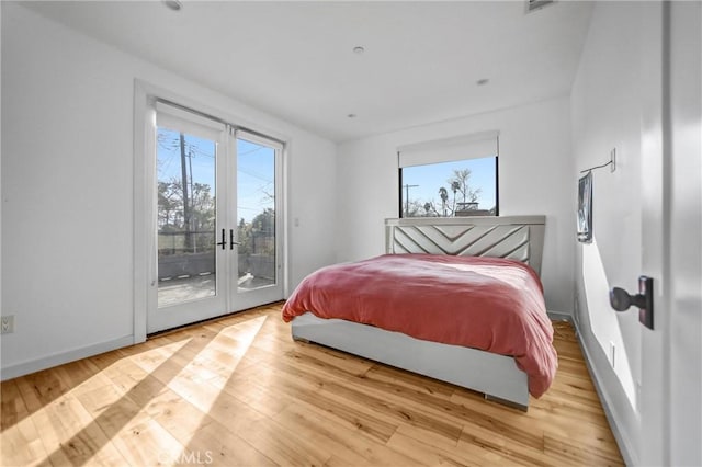 bedroom featuring access to exterior and light hardwood / wood-style floors