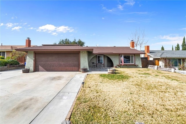 ranch-style home with a garage, a front yard, and a patio area