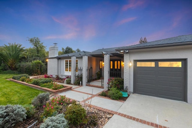 view of front of property with a garage and a lawn