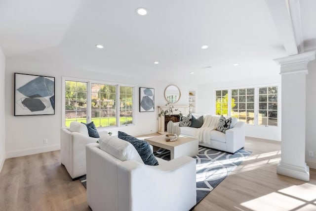 living room featuring light hardwood / wood-style floors and decorative columns