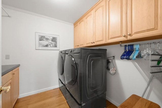 washroom with cabinets, crown molding, light wood-type flooring, and independent washer and dryer