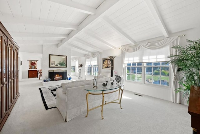 living room with light colored carpet, a healthy amount of sunlight, a brick fireplace, and vaulted ceiling with beams