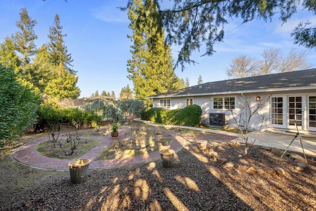 view of yard with a patio, central AC unit, and french doors