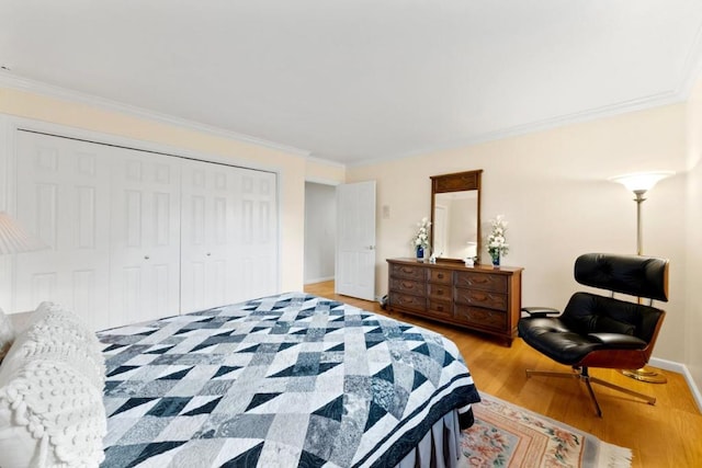 bedroom with crown molding, a closet, and light wood-type flooring