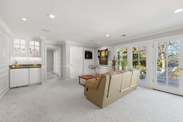 carpeted living room featuring ornamental molding and indoor bar