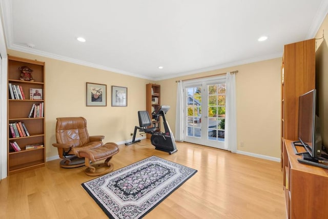 workout room featuring ornamental molding and light wood-type flooring