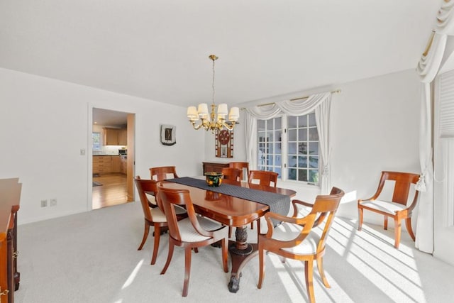 carpeted dining area with a chandelier