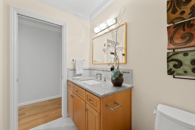 bathroom with crown molding, vanity, toilet, and wood-type flooring