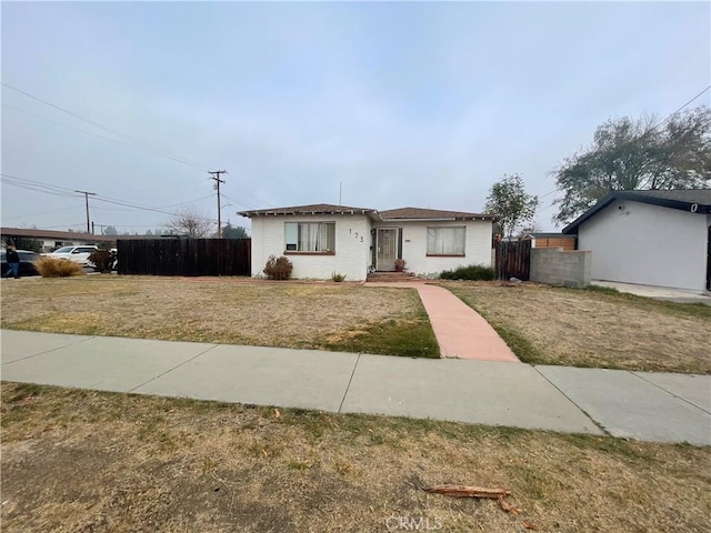 single story home featuring a front lawn