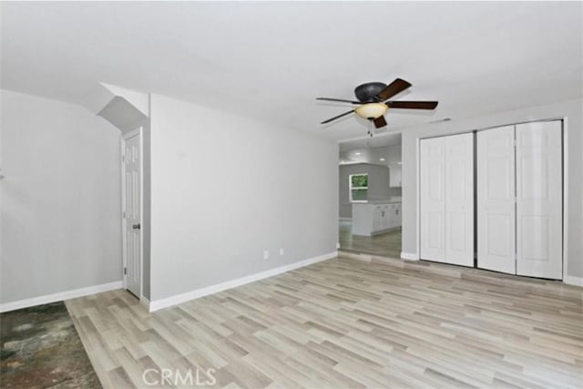 unfurnished bedroom with ceiling fan, a closet, and light wood-type flooring