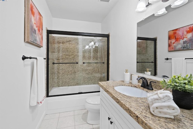 full bathroom featuring bath / shower combo with glass door, vanity, tile patterned floors, and toilet