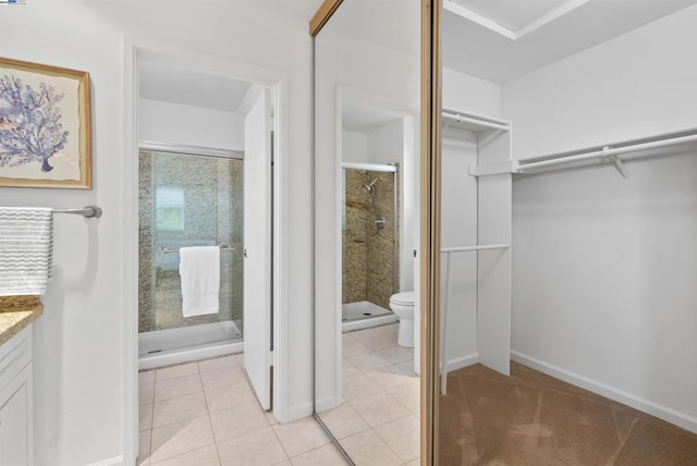 bathroom featuring vanity, toilet, tile patterned floors, and walk in shower