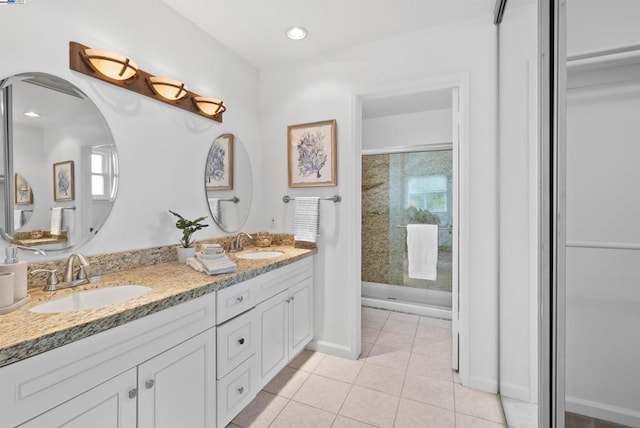 bathroom with vanity, tiled shower, and tile patterned floors