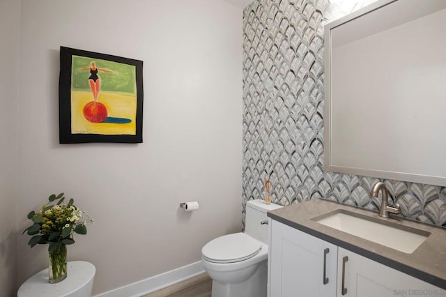 bathroom with vanity, toilet, and decorative backsplash