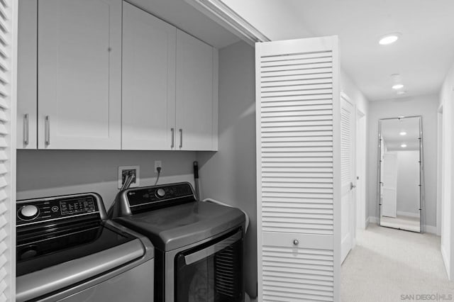 laundry room featuring cabinets, washing machine and dryer, and light carpet