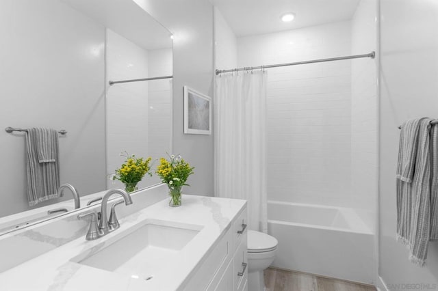 full bathroom with vanity, hardwood / wood-style floors, shower / bath combo with shower curtain, and toilet