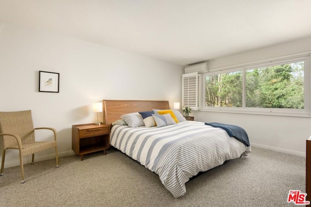 bedroom featuring a wall unit AC and carpet