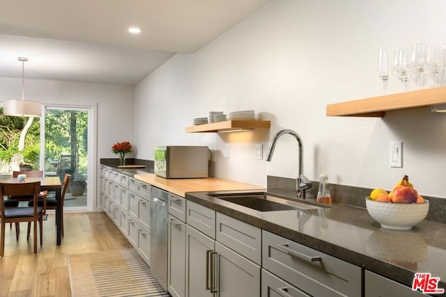 kitchen featuring pendant lighting, sink, light hardwood / wood-style flooring, dishwasher, and gray cabinetry