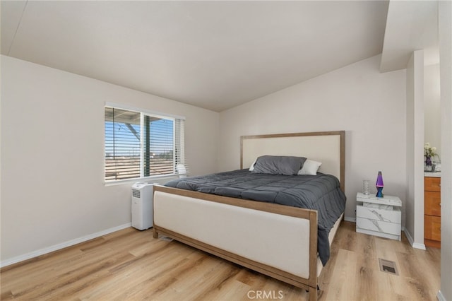 bedroom featuring vaulted ceiling and wood-type flooring